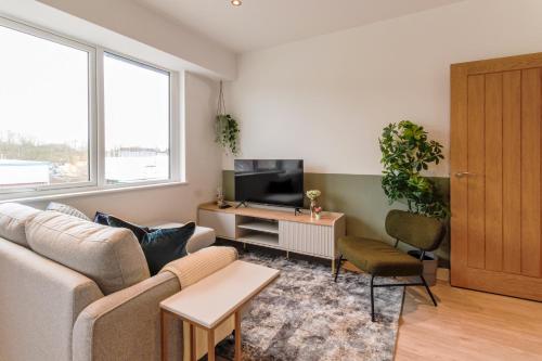 sala de estar con sofá y TV en Stirling Redhill by Pay As U Stay en Redhill