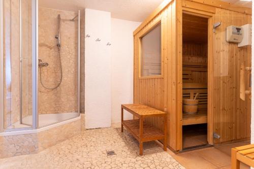 a bathroom with a shower and a wooden cabinet at Fischerhaus am Strand Appartement Kuschelnest in Brösum