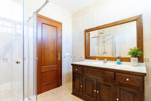 bagno con lavandino, doccia e specchio di Villa Ibiza Alcudia Mallorca a Alcudia