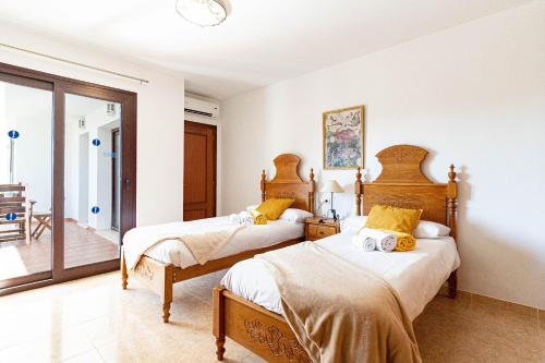 una camera con 2 letti e un balcone di Villa Ibiza Alcudia Mallorca a Alcudia