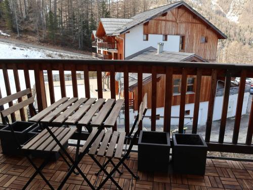 une table et des chaises sur une terrasse avec une cabine dans l'établissement Duplex 6 pers avec piscine, parking et animaux admis aux Orres 1800 - FR-1-322-413, aux Orres