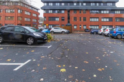 un estacionamiento con autos estacionados frente a un edificio en Redhill Apartments by Pay As U Stay en Redhill