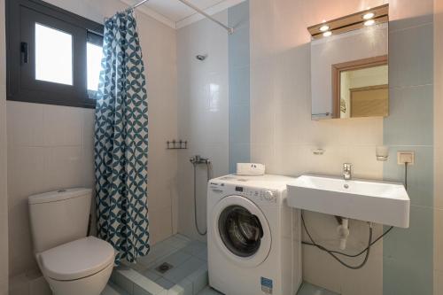 a bathroom with a washing machine and a sink at #FLH - Amalthia & Αthena Beachfront Houses in Pefkohori in Pefkohori