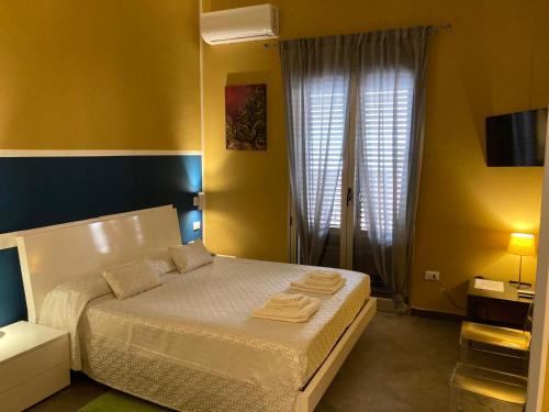 a bedroom with a bed with towels on it at B&B Palazzo Diaz in Marsala