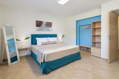 a bedroom with a large bed and a mirror at #FLH - Amalthia & Αthena Beachfront Houses in Pefkohori in Pefkohori