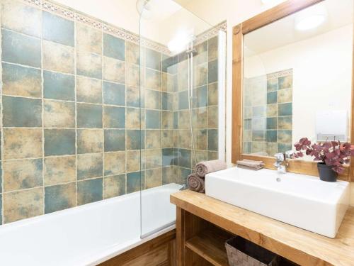 ein Badezimmer mit Waschbecken, Badewanne und Spiegel in der Unterkunft Appartement central à Saint-Lary avec piscine, sauna et parking sécurisé - FR-1-296-398 in Saint-Lary-Soulan