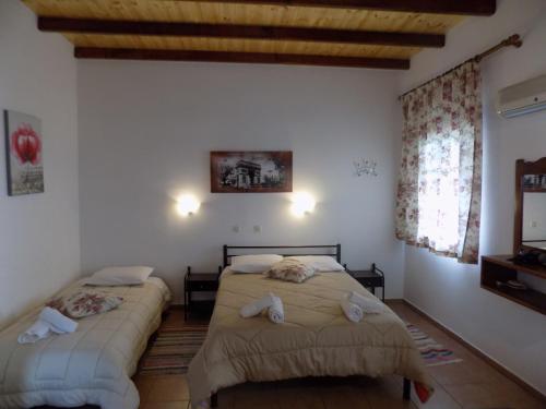 two beds in a room with white walls at villa elli panoramic view 2 in Ýpsos