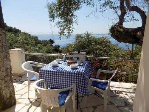 a table and chairs on a patio with a view of the ocean at villa elli panoramic view 2 in Ýpsos