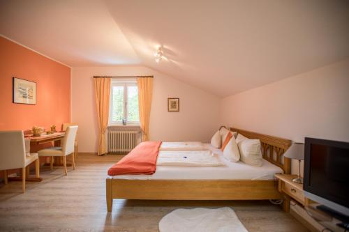 a bedroom with a bed and a desk and a television at Ferienwohnung Alpennelke in Füssen