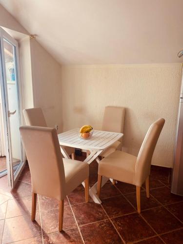 a dining table and chairs in a room at Apartman Jaca in Mrčevac