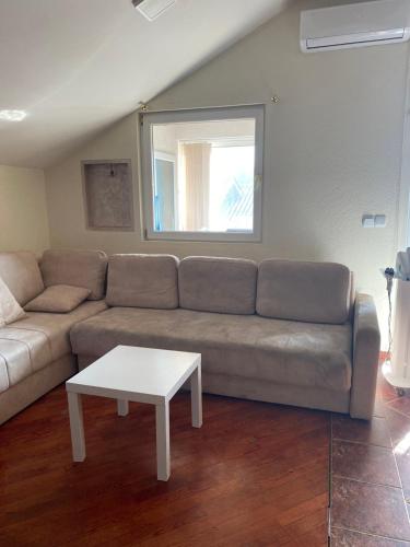 - un salon avec un canapé et une table dans l'établissement Apartman Jaca, à Mrčevac