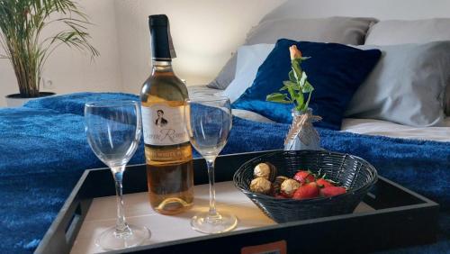 a bottle of wine and two wine glasses on a tray at Apartament Mar&Mel in Głuchołazy