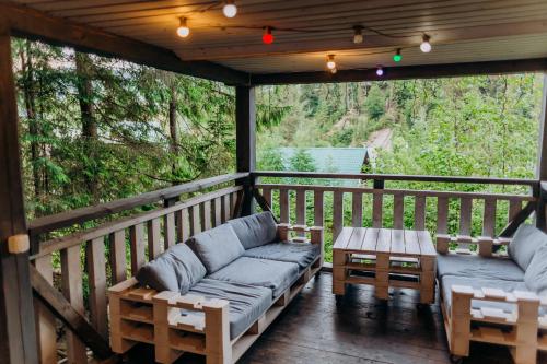 a screened in porch with couches and a table at Hotel Vedmezhyi Dvir in Bukovel