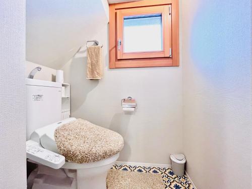 a small bathroom with a toilet and a window at 池袋Apila in Tokyo
