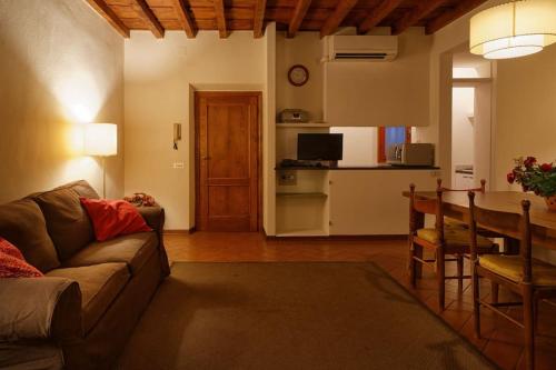 een woonkamer met een bank en een tafel en een keuken bij Corno in Florence