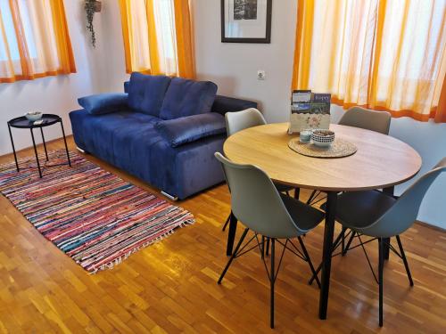 ein Wohnzimmer mit einem blauen Sofa und einem Tisch in der Unterkunft Istrian old town apartment in Koper