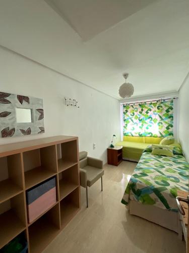 a bedroom with a bed and a couch and a window at Eva Santa pola in Santa Pola