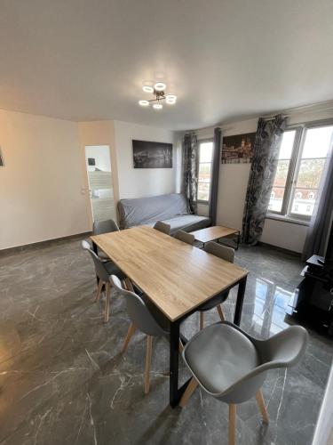 un salon avec une table et des chaises en bois dans l'établissement Appartement Lagny sur Marne DisneyLand Paris, à Lagny-sur-Marne