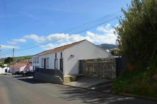 a small white house on the side of a street at Casas do Vale - T1 in Nordeste