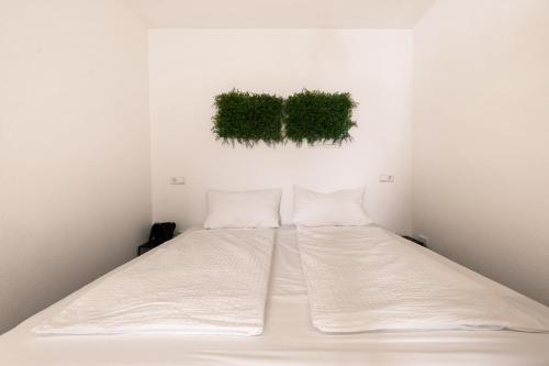 1 cama en una habitación con plantas verdes en la pared en Einzimmerwohnung in Seenähe klimatisiert, en Friedrichshafen