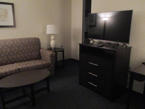 a living room with a couch and a television in a hotel room at AmericInn by Wyndham Hayward in Hayward
