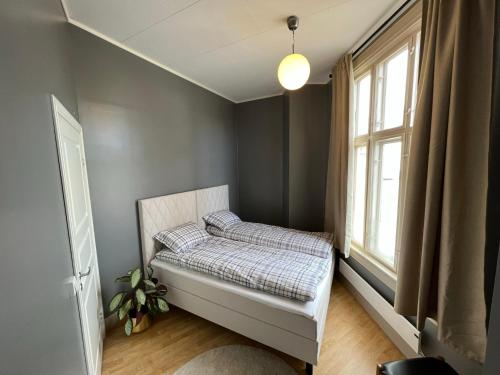 um quarto com uma cama e uma janela em Fredrikstad Cicignon, peaceful but central with garden, parking and long stay facilities em Fredrikstad