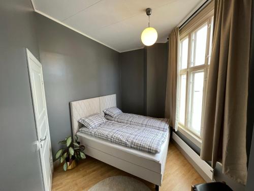 a bedroom with a bed and a window at Fredrikstad Cicignon, peaceful but central with garden, parking and long stay facilities in Fredrikstad