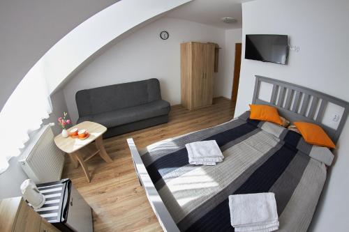 een slaapkamer met een bed en een bank in een kamer bij Pokoje u Mirka in Dźwirzyno