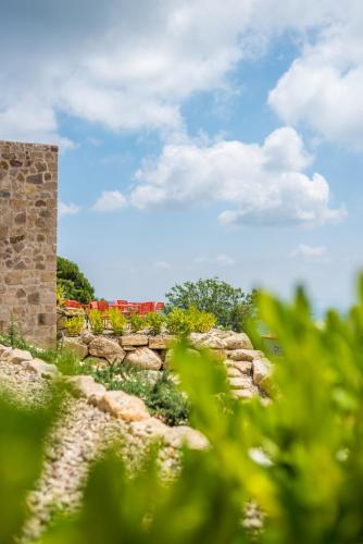 a stone wall with flowers in the background at VALDONICA WINERY Fine Dine & Wine Hotel in Sassofortino