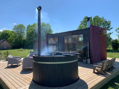 a wooden deck with a fire pit and a house at Jaagu-Mihkli Muhu Island in Ridasi