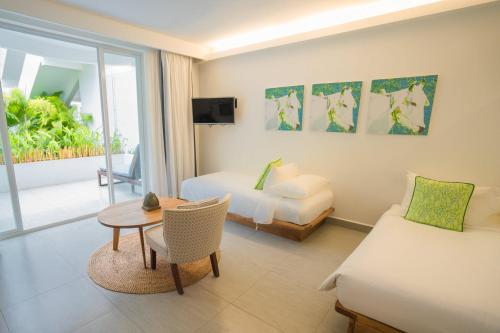 Pokój hotelowy z łóżkiem, stołem i kanapą w obiekcie Naiya Sea Resort w mieście Preăh Sihanŭk