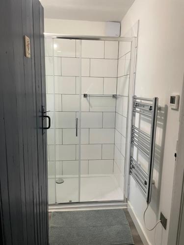 a shower with a glass door in a bathroom at Borthwick Farm Cottage Annex in Gorebridge