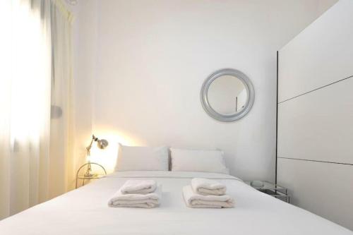 a white bedroom with a bed with towels on it at Athens Tower 2 Bedroom Apartment by SuperHost Hub in Athens