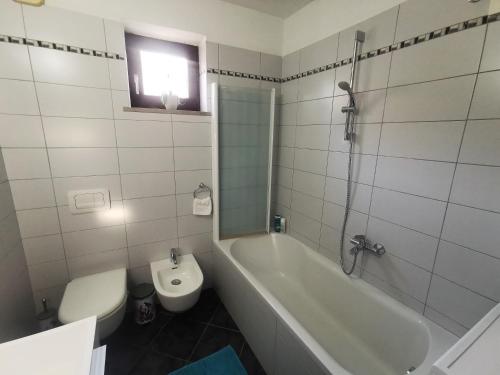 ein Badezimmer mit einer Badewanne, einem WC und einem Waschbecken in der Unterkunft Istrian old town apartment in Koper