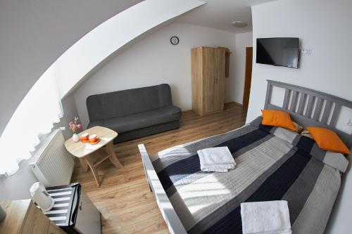 una camera con letto e divano di Pokoje u Mirka a Dźwirzyno