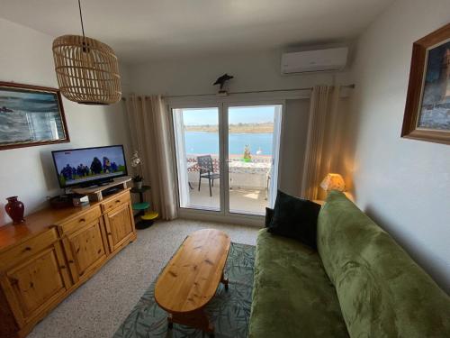 a living room with a couch and a table and a television at Appartement Vue mer et Parc naturel in Roses