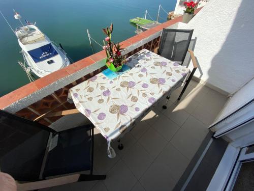 a table and chairs on a balcony with a boat at Appartement Vue mer et Parc naturel in Roses