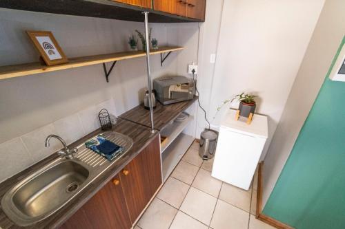 Il comprend une petite cuisine équipée d'un évier et d'un four micro-ondes. dans l'établissement Mulkana, à Bloemfontein