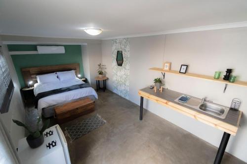 Cet appartement comprend une chambre avec un lit et un évier ainsi qu'une cuisine. dans l'établissement Mulkana, à Bloemfontein