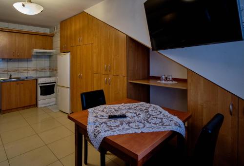 a kitchen with a wooden table and a kitchen with a counter at Bohema Restauracja i Noclegi in Supraśl
