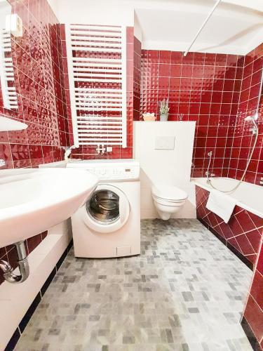 La salle de bains est pourvue de carrelage rouge, de toilettes et d'un lavabo. dans l'établissement Apartment Schützenwiese, à Hildesheim