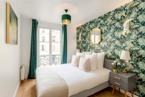a bedroom with a large white bed with a floral wallpaper at Cosy 4 Bedrooms 2 Bathr Apartment - Champs Elysées in Paris