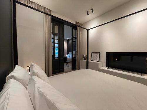a bedroom with a white bed and a flat screen tv at 3 Bedroom Art-Nouveau Apartment with Free Parking in Ghent