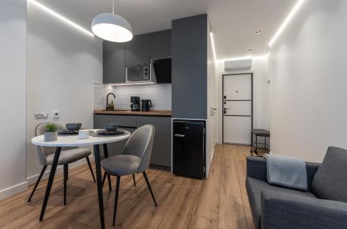 a kitchen and a living room with a table and a couch at Shades of gray - NEW DELUX Apartments in Kyiv
