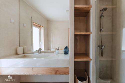 uma casa de banho com um lavatório e um espelho em Casa da Azenha Deluxe em Santa Cruz