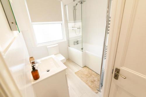 a white bathroom with a sink and a shower at Mulberry Cottage - Cosy 3 Bed Cottage near Lytham Windmill in Lytham St Annes