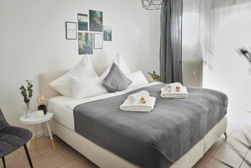a bedroom with a bed with towels on it at Ajko Homes - Design Apartment - Parkplatz - Balkon - Netflix - 6 Pers in Walldorf