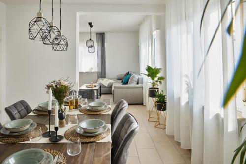 una sala da pranzo con tavolo e sedie e un soggiorno di Ajko Homes - Design Apartment - Parkplatz - Balkon - Netflix - 6 Pers a Walldorf