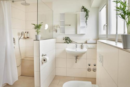 La salle de bains blanche est pourvue d'un lavabo et de toilettes. dans l'établissement IDEE Living Design Apartment Balkon - Netflix - 6 Pers, à Walldorf