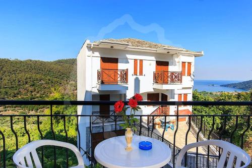 a balcony with a table and chairs and a building at Zeus Guesthouse in Panayia